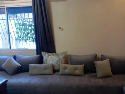 a couch with pillows on it with a window at Jana in Meknès