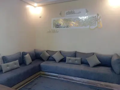 a living room with a blue couch with pillows at Jana in Meknès