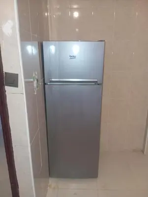 a stainless steel refrigerator sitting in a kitchen at Jana in Meknès