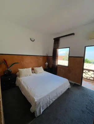 a bedroom with a large white bed with a window at Hôtel Imouzzer in Ourika