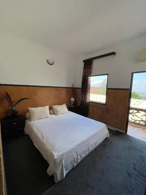 a bedroom with a large white bed with a window at Hôtel Imouzzer in Ourika