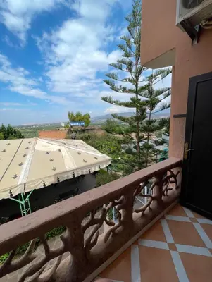 a balcony with a tree and a building at Hôtel Imouzzer in Ourika