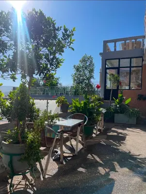a patio with tables and chairs and potted plants at Hôtel Imouzzer in Ourika