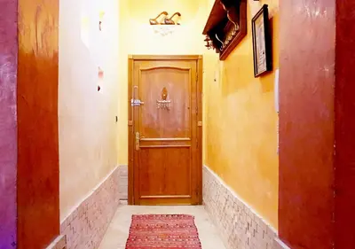 a hallway with a wooden door and a rug at Moroccan apartment riad style in Fès