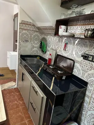 a small kitchen with a sink and a stove at Taghazout Hostel in Oulad Akkou