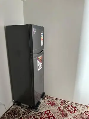 a black refrigerator in a corner of a room at Taghazout Hostel in Oulad Akkou