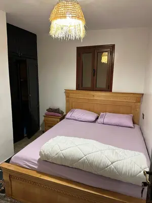 a bedroom with a bed and a chandelier at Taghazout Hostel in Oulad Akkou