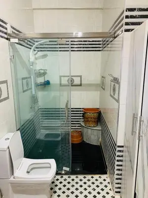 a bathroom with a shower and a toilet and a sink at Al confort in Fès