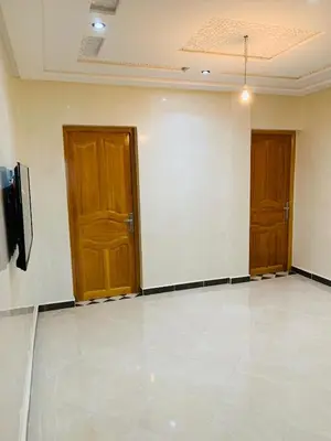 a room with two wooden doors and a white wall at Al confort in Fès