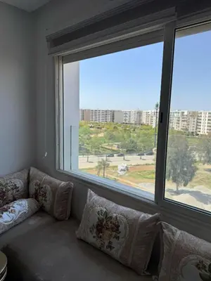 a couch in a room with a large window at Luxueux appartement centre ville wifi 200 Mo in Fès