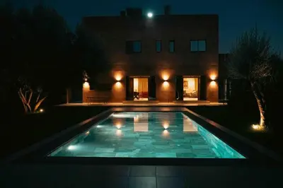 a swimming pool in front of a house at night at Villa Azuréa with pool 4 bedrooms and 2 living rooms in Ourika