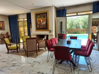 a dining room with a table and chairs at Villa Azuréa with pool 4 bedrooms and 2 living rooms in Ourika