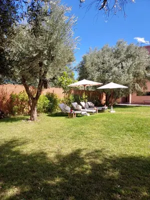 a group of chairs and umbrellas in a yard at Villa Azuréa with pool 4 bedrooms and 2 living rooms in Ourika