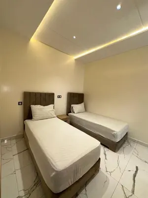 two beds in a hotel room with white sheets at Etoile De Sidi Harazem in Station de Sidi Harazem