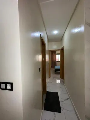 a hallway with white walls and a floor with a rug at Etoile De Sidi Harazem in Station de Sidi Harazem