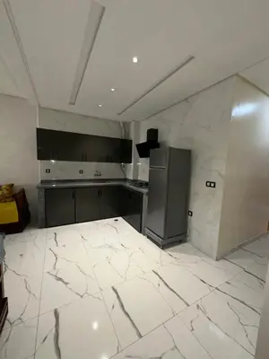 a kitchen with white marble floors and a refrigerator at Etoile De Sidi Harazem in Station de Sidi Harazem