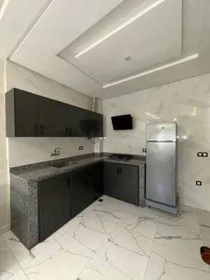 a large white kitchen with a refrigerator in it at Etoile De Sidi Harazem in Station de Sidi Harazem