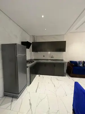 a kitchen with stainless steel appliances and a blue couch at Etoile De Sidi Harazem in Station de Sidi Harazem