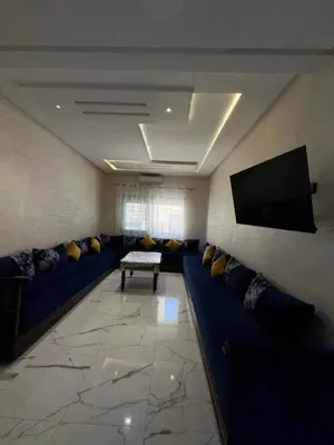 a living room with blue couches and a flat screen tv at Etoile De Sidi Harazem in Station de Sidi Harazem