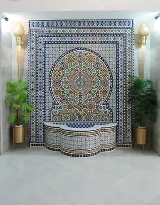 a bathroom with a large mosaic tile wall with a tub at Hôtel Asswar Al Madina in Fès