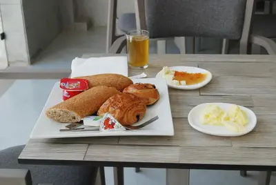 a plate of food with bread and other foods on a table at Hôtel Asswar Al Madina in Fès