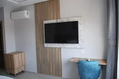 a living room with a tv on a wall at Hôtel Asswar Al Madina in Fès