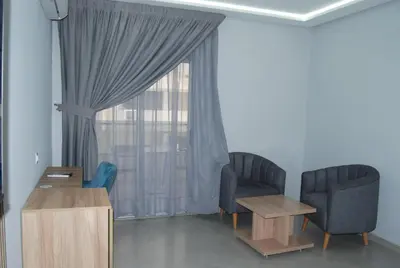 a living room with two chairs and a window at Hôtel Asswar Al Madina in Fès
