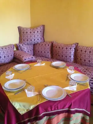 a table with plates and napkins on a couch at Dar Lamrani in Rissani