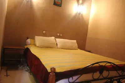 a bedroom with a bed with a light on the wall at Dar Lamrani in Rissani
