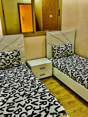 two beds sitting next to each other in a room at Dar location luxury in Meknès