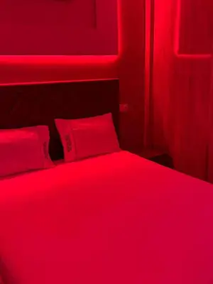 a red bedroom with a bed with two red pillows at Dar location luxury in Meknès