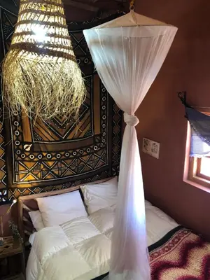 a bedroom with a bed with a curtain and a chandelier at Chill and welcoming flat in Tagounite in Tagounite