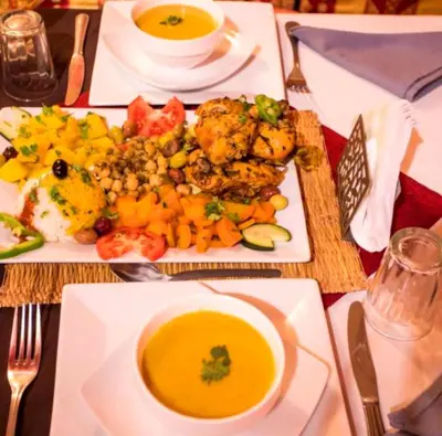 a table with a plate of food and a bowl of soup at Desert Berber Luxury Camp in Merzouga