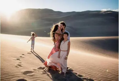 a family standing in the sand in the desert at Desert Berber Luxury Camp in Merzouga