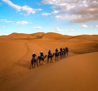 a group of people riding horses in the desert at Desert Berber Luxury Camp in Merzouga