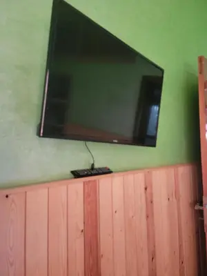 a flat screen tv hanging on a green wall at Ourika atlas home in Setti Fatma