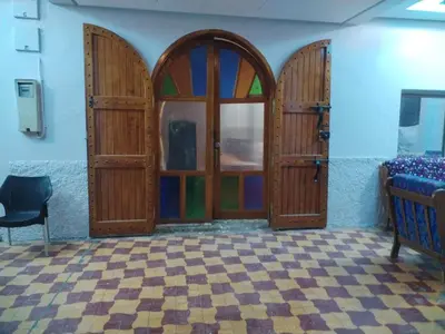 a room with wooden doors and a checkered floor at almou auberge imilchil in Imilchil