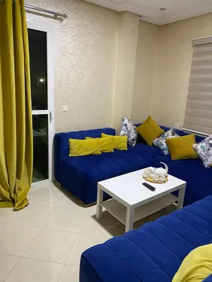 a living room with a blue couch and a table at Jnane meknes in Meknès