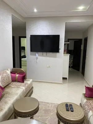 a living room with couches and a flat screen tv at Jnane meknes in Meknès