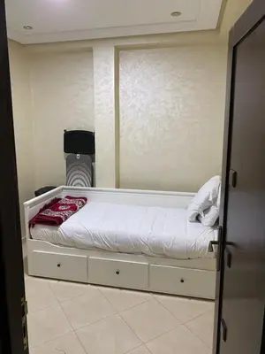 a small bedroom with a bed with a mirror at Jnane meknes in Meknès