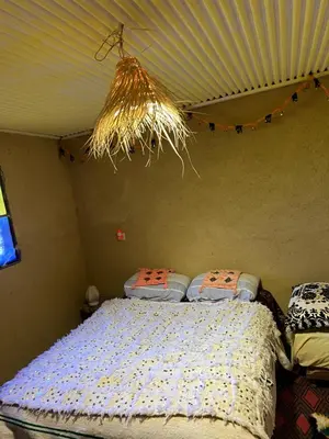 a bedroom with a bed and a ceiling with lights at Gite Amani Guest House in Zaouia Hansala