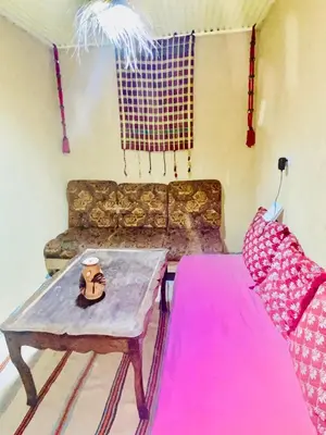 a living room with a table and a couch at Gite Amani Guest House in Zaouia Hansala