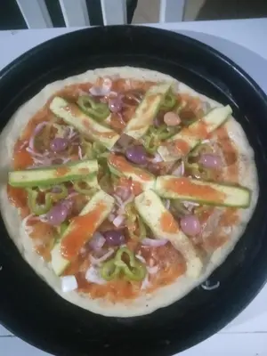 a pizza in a black pan on a table at Mahdi gajli in Ouarzazate