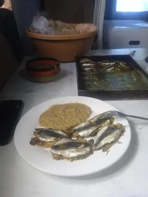 a plate of sardines on a table with a plate of food at Mahdi gajli in Ouarzazate