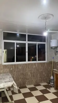 a living room with a checkered floor and windows at Appartement Ritage in Meknès
