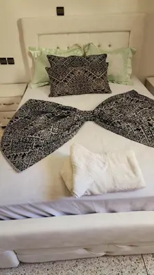 a bed with two blankets and pillows on it at Appartement Ritage in Meknès
