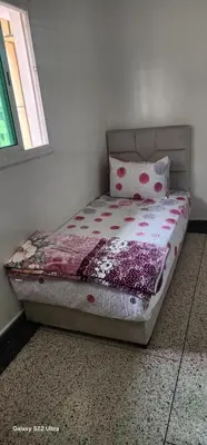 a bedroom with a bed with a pillow and a window at Appartement Ritage in Meknès