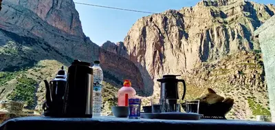 a table with bottles on it with a view of a mountain at gite taghia ahanssal in Taghia