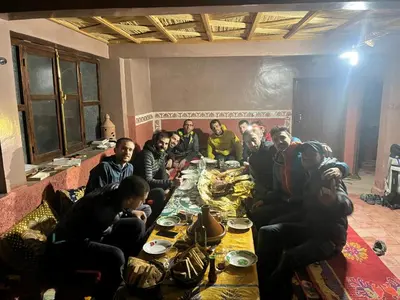 a group of people sitting around a table with a dog at gite taghia ahanssal in Taghia