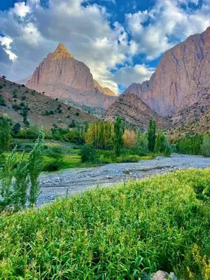 a river in a field with mountains in the background at gite taghia ahanssal in Taghia
